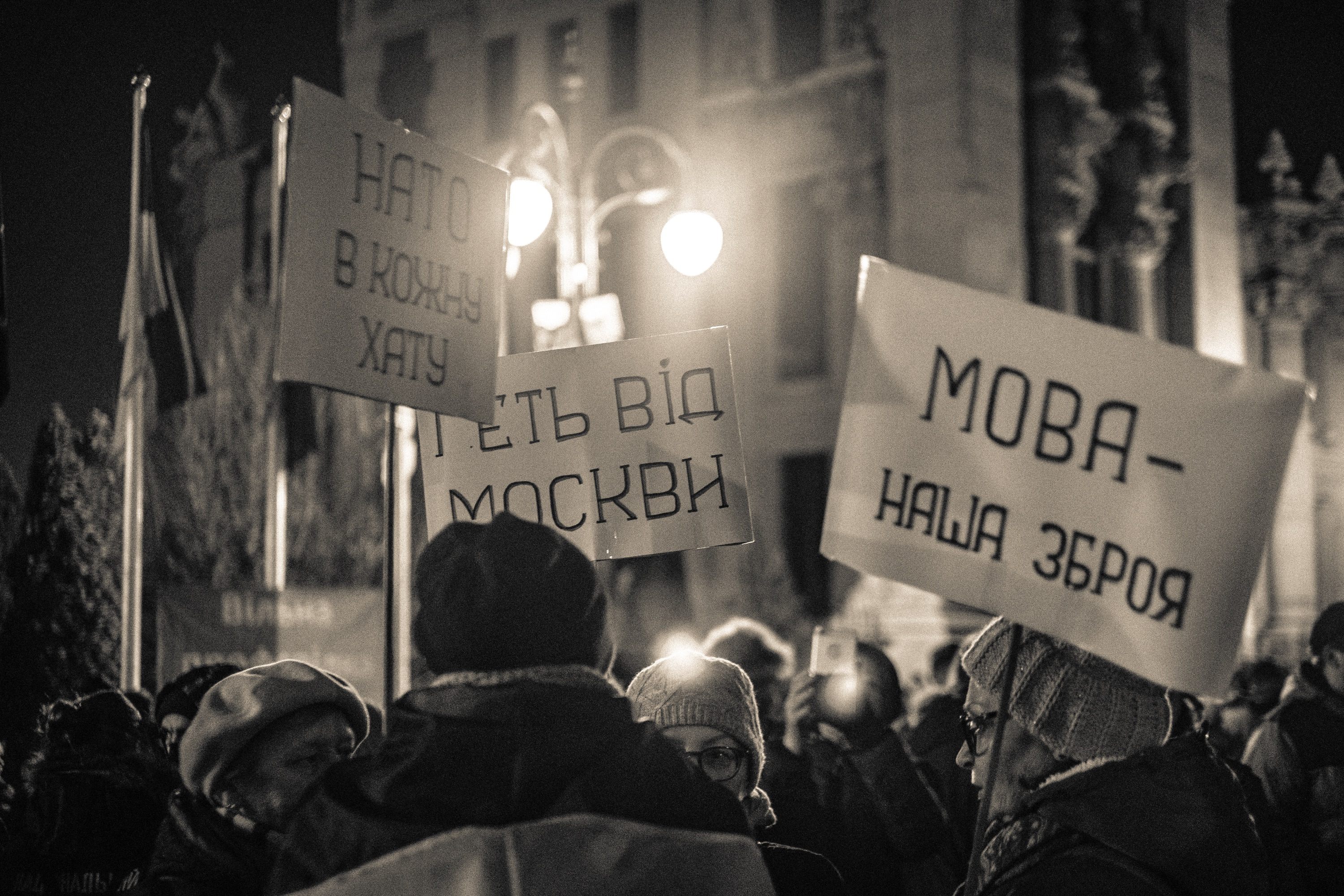 Protest signs in a nighttime crowd