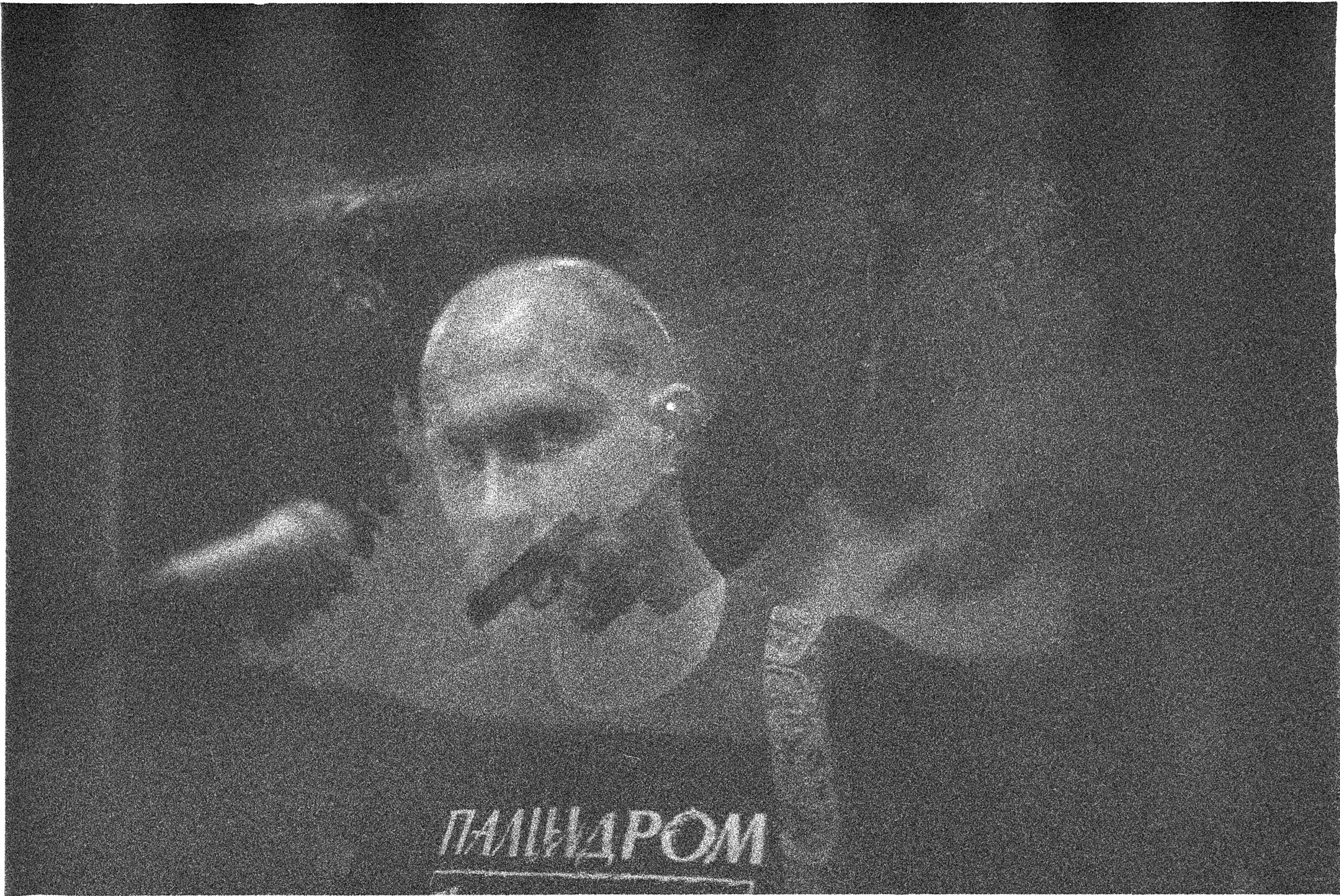 A grainy portrait on a dark screen